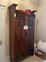 Full front view of wardrobe showing two carved doors, top cornice, and overall proportions