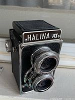 Side angle showing the general form and twin lenses of the Halina A1 camera.