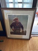 Framed limited edition print by Ray Swanson shown standing against a wall on a wooden floor, framed under glass with visible sticker showing number 151/400.