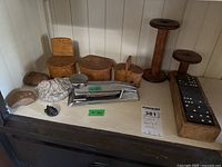 Three burl oak trinket boxes, two wooden spools, vintage boxed dominoes, chrome stapler, and several rocks and fossils displayed together.