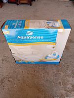 Box front showing AquaSense Toilet Seat Riser with product image and brand name.