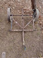 Top down view of the steel wagon cart showing the frame, wheels and pull arm clearly on uneven ground with leaves