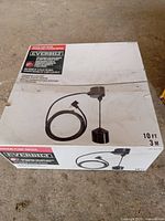 Top view of the boxed Everbilt vertical float switch with 10 ft cable showing product image and branding.