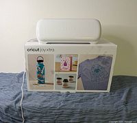 Closed Cricut Joy Xtra machine resting on its original retail box