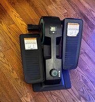 Top-down view of the black Cubii seated elliptical showing pedals, digital display and resistance knob.