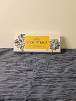 Closed box of Pure Essentials with botanical drawings and yellow label.