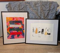 Front view of two black framed art prints showing colorful abstract and fashion sketch prints