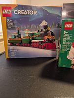 Box of LEGO Creator 40700 Winter Holiday Train with festive green and red train and holiday cargo.