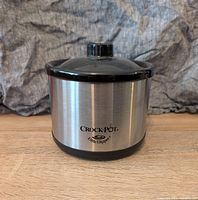 Mini Crockpot front view showing stainless steel body with Crock-Pot and Little Dipper logo.