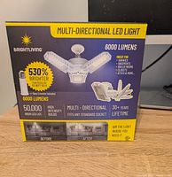 Box front of Bright Living multi-directional LED light showing product features and specifications.