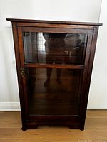 Front view of oak cabinet showing door and shelves