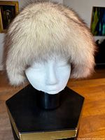 Front view of the ladies fur hat on a mannequin head showing the dense white and brown fox fur.