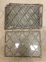 Four rectangular leaded window panes stacked showing diamond pattern leaded metal lattice grid over clear glass.