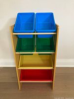 Front view of the full storage rack with six color-coded bins: blue (top), green (second level), yellow (third level), red (bottom)