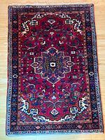 Full view of rectangular red Persian area rug with central medallion and floral pattern