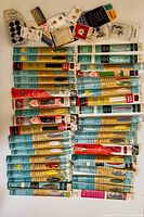 Overview of all packaged sewing zippers laid flat, arranged by size and color, with assorted packaged fasteners including hooks, eyes, and snaps at the top of the layout.