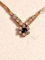 Close-up of necklace pendant showing sapphire and CZ stones