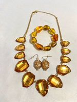 Full view of necklace, earrings and bracelet laid flat