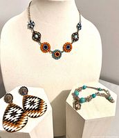 Necklace, bracelet and earrings grouped on display stands