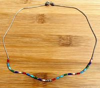 Necklace laid flat showing full design and colored beads