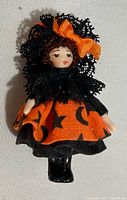 Front view of miniature doll in Halloween outfit