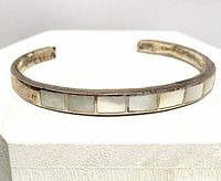 Front view of sterling cuff displaying mother of pearl tiles