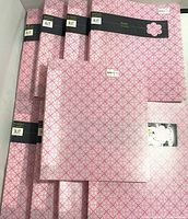 Stack of nine Kit pink patterned binders