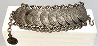 Top view of full bracelet showing linked coin medallions and extender chain