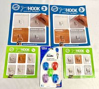 Front view of two large Jimmy Hook packs, two small Jimmy Hook packs, one Office Depot cubicle hooks pack