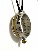 Side view of ring sundial showing pewter body, brass band, gnomon bead, black cord