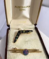 Open presentation box showing both opal brooches