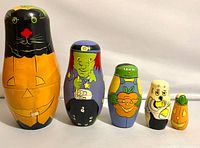 Front view of all five nesting dolls lined up by size