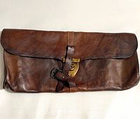 Front view of brown leather pouch showing flap, clasp, and strap