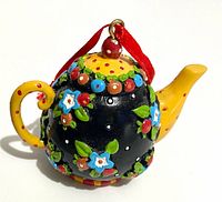 Full view of teapot ornament showing shape, colors, ribbon