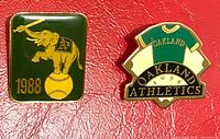 Both Oakland A's enamel cap pins side by side