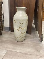 Front view of the tall ceramic vase showing off-white color and bamboo pattern design.