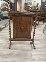 Front view of traditional wooden linens rack showing twisted posts and carved details