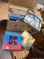 Box filled with stacked LP sleeves and three albums laid out: Steve Miller Band, unidentified singer and Steve Miller Band front cover.