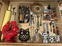 Photo of drawer contents showing various kitchen utensils and decorative items