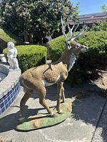 Front right view of standing buck deer statue outdoors