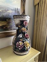 Front and side view of large vintage Italian ceramic vase with pink and yellow 3D flowers and detailed ceramic trim near the rim.