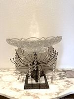 Front view of the Hollywood Regency crystal bowl pedestal showing scalloped edged crystal bowl atop intricate metal base with hanging crystal prisms.