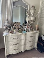 Full view of white dresser with matching mirror and decorative items (not included).