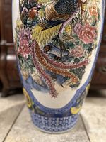 Close-up of floor vase showing detailed hand-painted bird and floral designs in multiple colors with intricate patterns and blue base decoration.