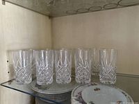 Eight vintage Godinger Dublin highball glasses displayed on a glass shelf, showing the front and side view.