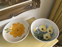 Pair of vintage Italian ceramic bowls with floral designs on a table