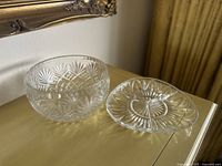 Photo of bowl and serving dish together on a wooden surface under a framed mirror, showing starburst and diamond cut patterns.
