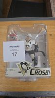 Front view of Sidney Crosby McFarlane action figure in original packaging, showing figure in Pittsburgh Penguins white uniform with visible captain's C.