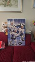 Picture of full wooden wall hanging with Toronto Maple Leafs players Corson, Tucker, and Roberts with Toronto skyline.