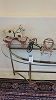 Photo showing the full set of three decorative items including the rocking horse, tricycle, and wagon chair on a glass-topped table